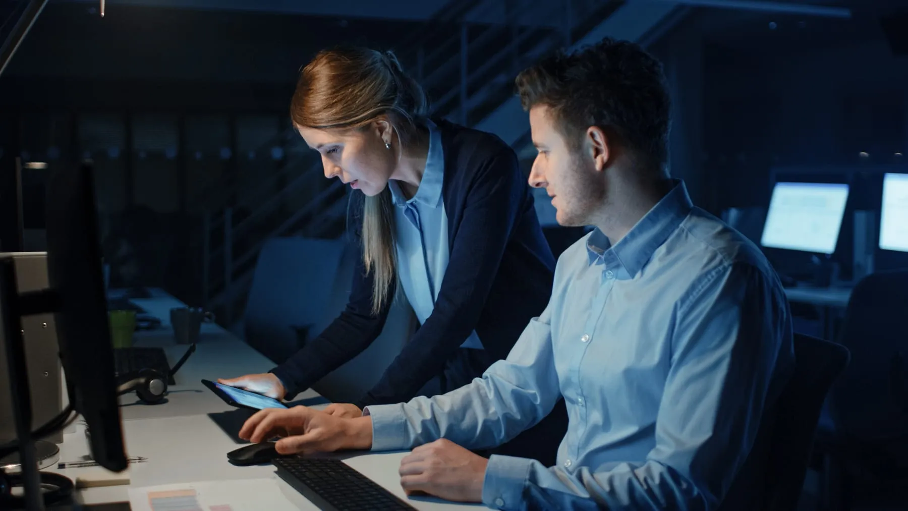 Ambitious confident businessman uses desktop computer his female project manager explains specific tasks account handling strategic moves professional