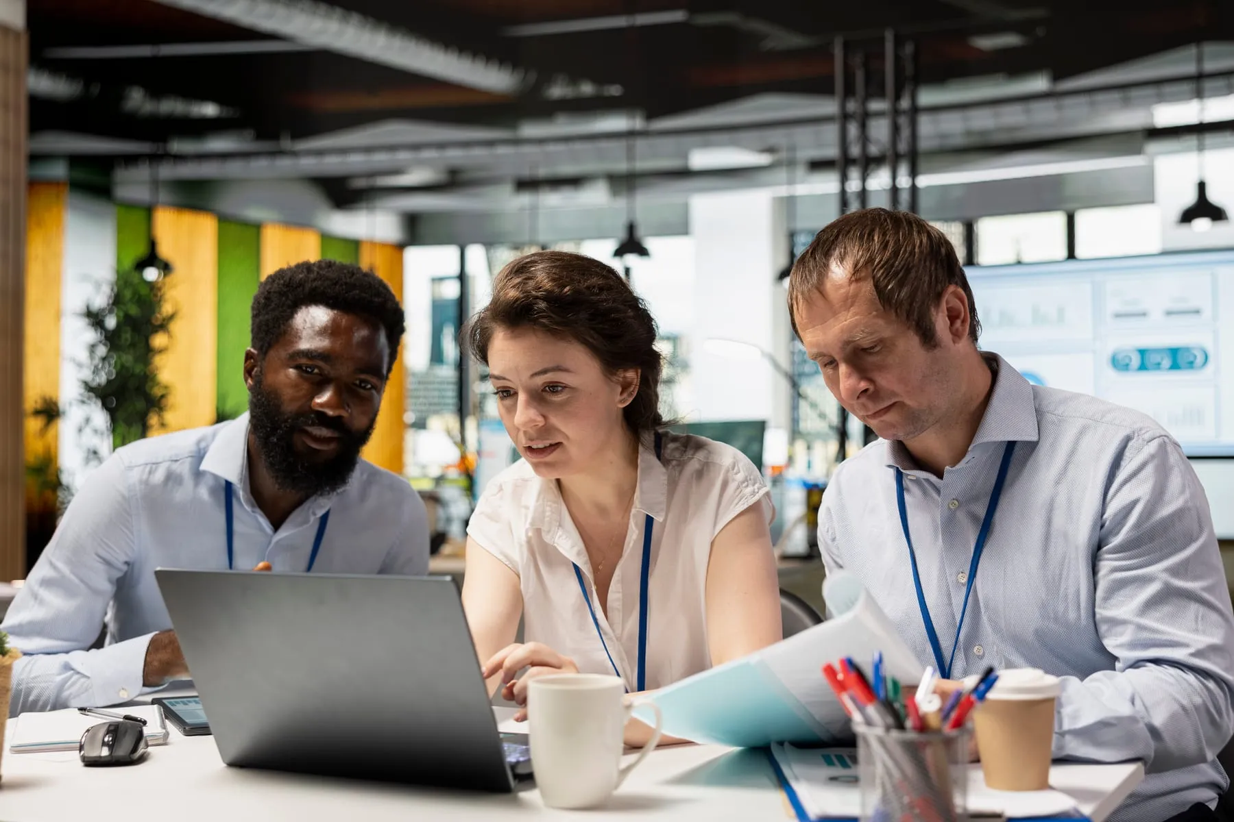 Multiethnic corporate team including black man caucasian individuals collaborating office