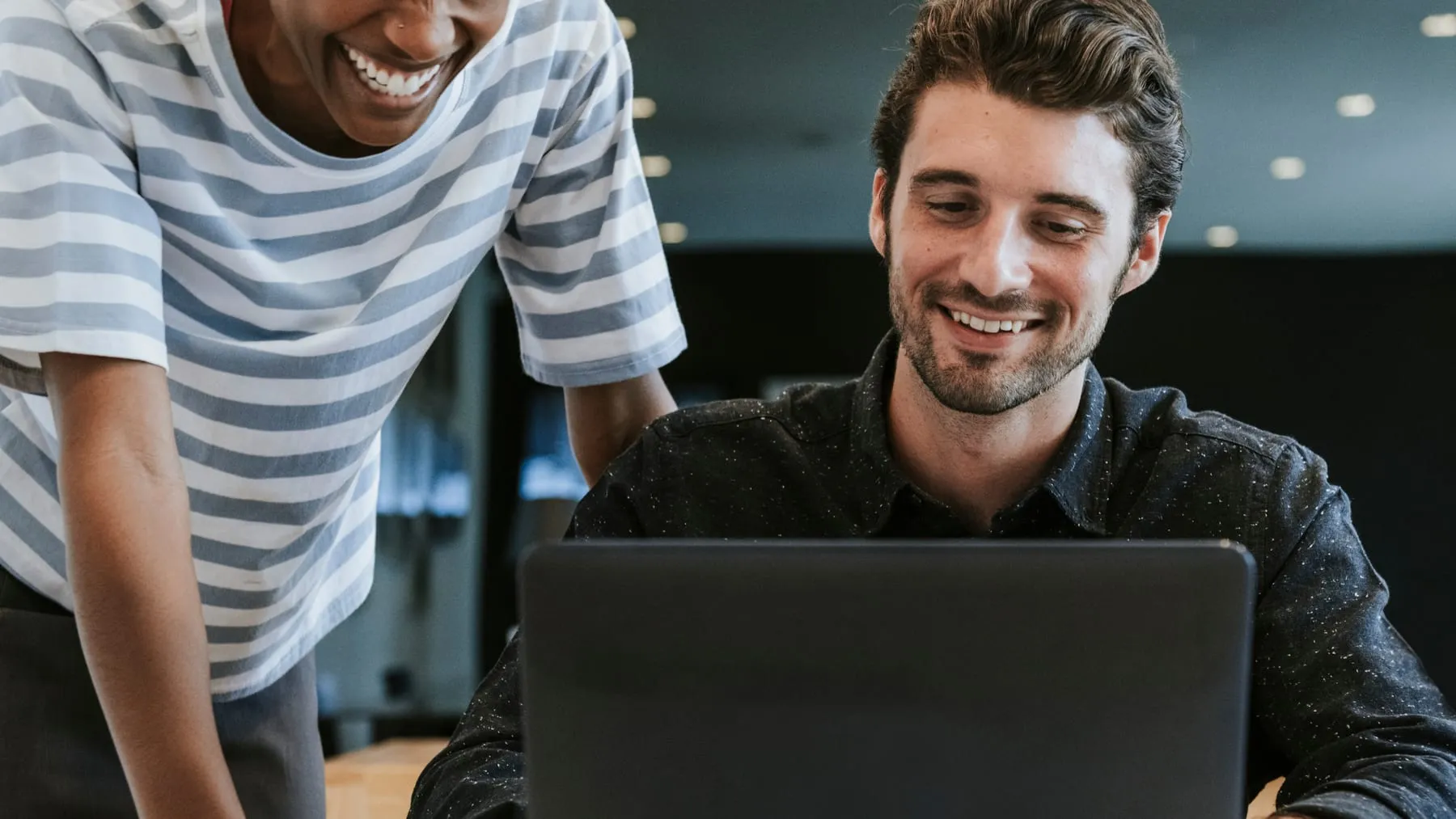 Colleagues discussing their work laptop