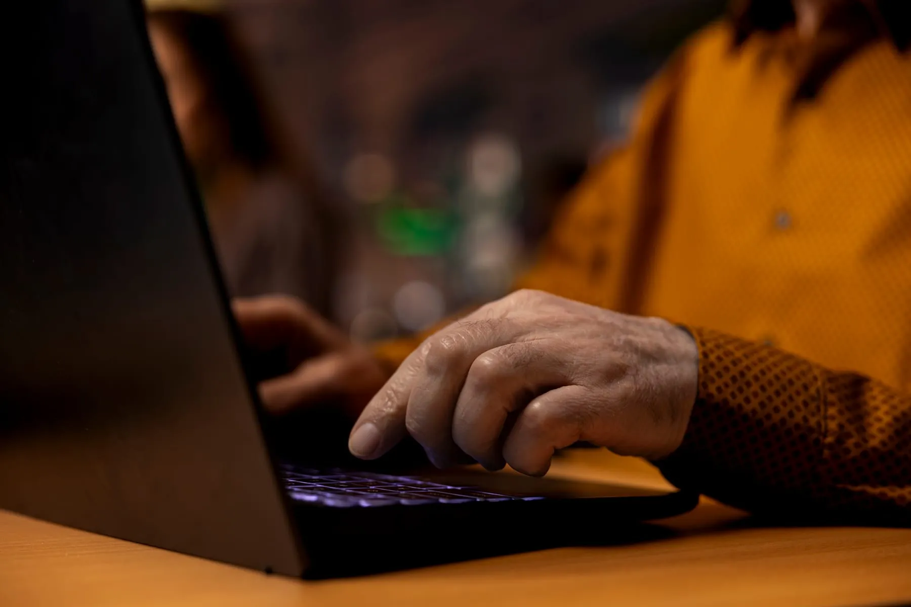Focused senior person reading academic text laptop university