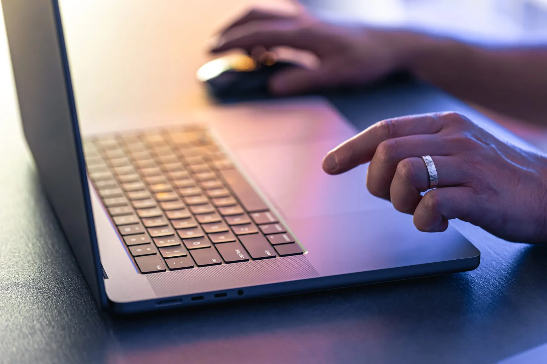 Man uses laptop night closeup his hands