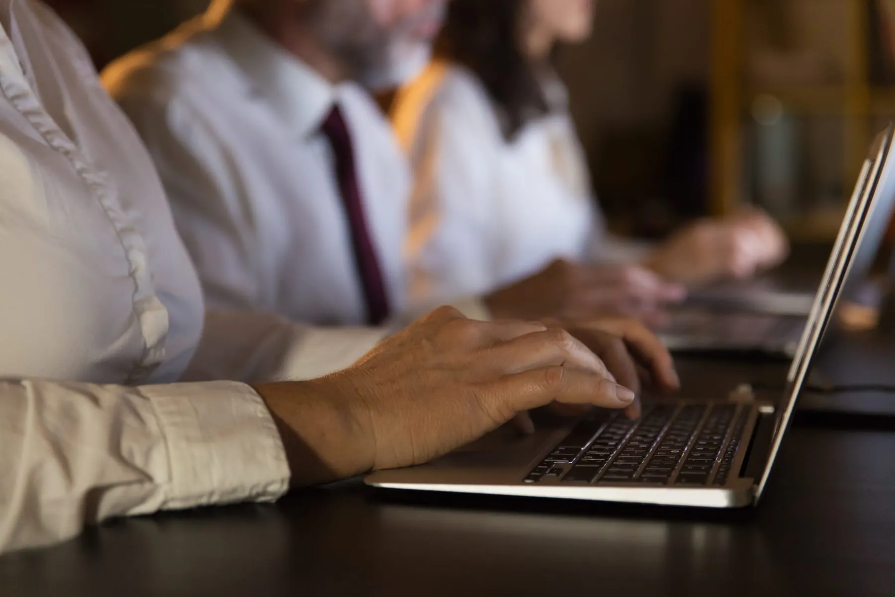 Partial view business people using laptops