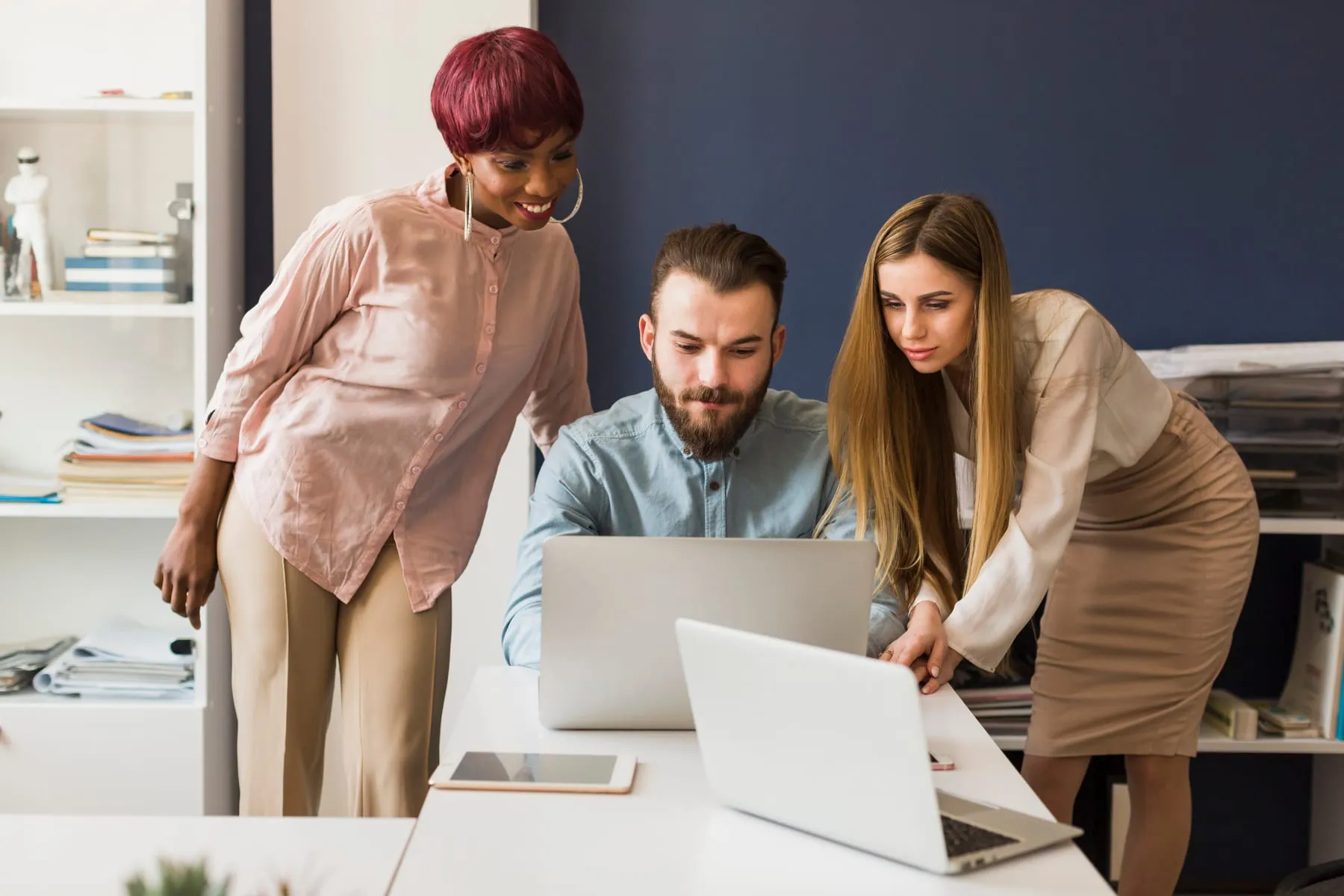 Women helping man with project